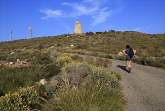 Woman walking Torre Vigia de los Lobos Rodalquilar, Cabo de Gata natural park, Almeria, Spain,