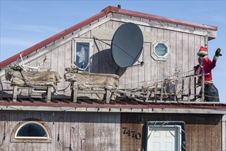 Santa Claus, Father Christmas on the roof of a simple wooden house, Barrow, Alaska, USA, North