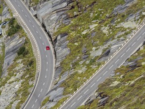 Single red car on Grimsel mountain pass, northern slopes above lake Grimsel, Switzerland, Europe