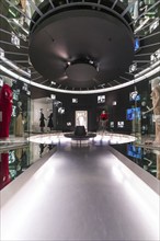 Futuristic exhibition space with illuminated mirrors and mannequins that form a walkway, Deutsche