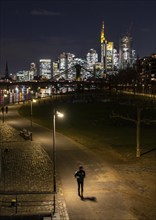 Skyline of the city centre of Frankfurt am Main, joggers on the pavement, promenade along the river