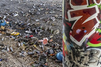 Empty spray paint cans, on a railway line below a road bridge, thrown away, disposed of by the