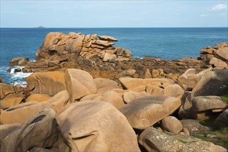 Orange-coloured rocks on the blue ocean under a slightly cloudy sky, Ploumanac'h, Ploumanach,