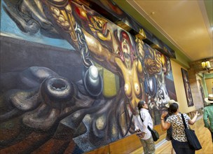 People viewing artwork 'Nueva Democracia' 1944 mural by David Alfaro Siqueiros, Palacio de Bellas