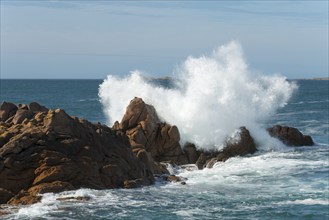 High waves crash against a rocky coastline under a clear sky, Ploumanac'h, Ploumanach,