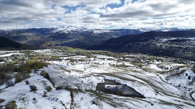 Aerial view of snow-covered fields and distant mountains under a cloudy sky. Posof, Ardahan, TURKEY