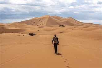 Hiking up the Great Dune of Merzouga in the Erg Chebbi desert, Moroccan Sahara desert