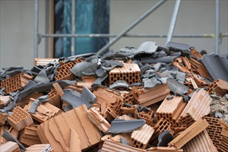 Close-up of mixed construction waste with new building in the background