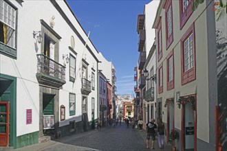 Lively street in an old town with historic facades under a blue sky, Santa Cruz de la Palma, La