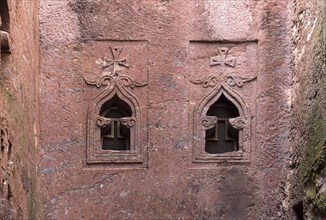 Pointed arch-shaped stone windows on the façade of the rock-hewn church of Biete Golgotha and