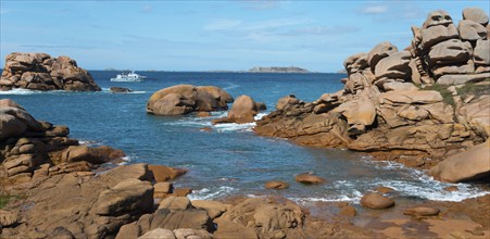 Rocky landscape with blue water and a boat on the horizon, Ploumanac'h, Ploumanach, Perros-Guirec,