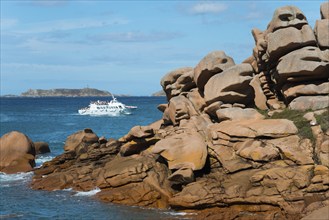 Rocky coast with passing boat and small island on the horizon, Ploumanac'h, Ploumanach,