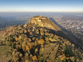 Aerial view of the Hohentwiel volcanic cone with the castle ruins illuminated by the evening sun,