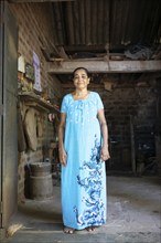 Sri Lankan craftswoman, 67 years old, wearing a blue dress in her workshop, Matale, Central