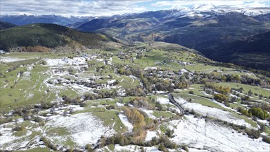 Aerial view of snow-patched fields surrounded by mountains and clouds. Posof, Ardahan, TURKEY