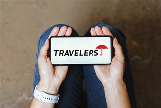 In this photo illustration, the Travelers Insurance logo is displayed on a smartphone screen