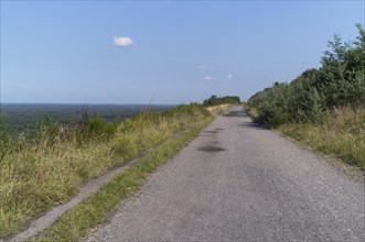 Wide gravel path on a hill with a distant view