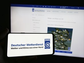 Stuttgart, Germany, 06-06-2024: Person holding smartphone with logo of German meteorological