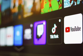 In this photo illustration the YouTube, TikTok and Twitch logo is displayed on a TV screen