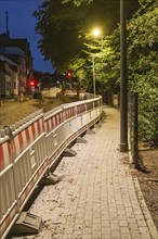 Roadworks with barriers and warning lights at night