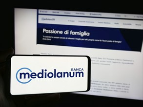 Stuttgart, Germany, 06-01-2024: Person holding smartphone with logo of Italian financial company