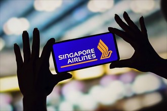 In this photo illustration, the Singapore Airlines logo is displayed on a smartphone screen