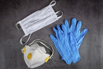 Protective medical mask, respirator and gloves on black background. Protective equipment against