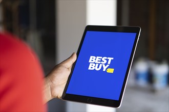 Best Buy logo is displayed on smartphone. Best Buy Co., Inc. is an American multinational consumer