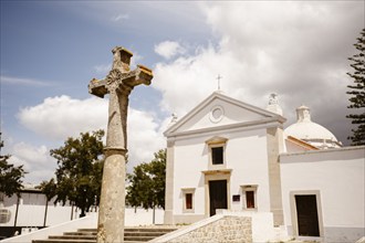 Small Chapel and big cross with cloudy sky in the background, Faro, Algarve, Portugal, Europe