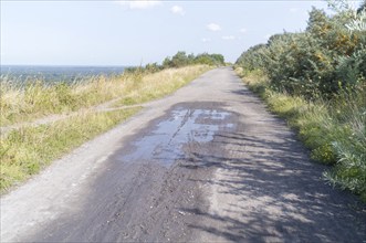 Wide gravel path on a hill with a distant view