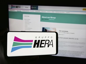 Stuttgart, Germany, 06-01-2024: Person holding smartphone with logo of Italian utility company Hera