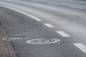 Empty road with cycle path and manhole cover