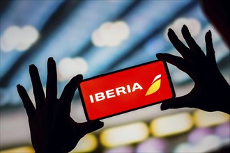 In this photo illustration, the Iberia logo is displayed on a smartphone screen