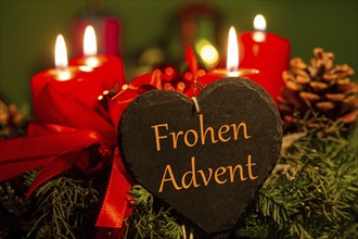 Adventsgrüße: Herz mit der Aufschrift FROHEN ADVENT vor einem Adventskranz