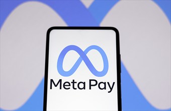 In this photo illustration the Meta Pay logo seen displayed on a smartphone and in the background