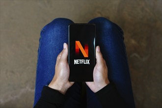 In this photo illustration, the Netflix logo seen displayed on a smartphone