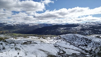 Bright panoramic view of a snow-covered mountainous region with a winding road. Posof, Ardahan,