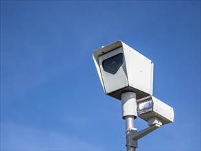 A close up to a traffic speed Camera or red light camera on a sunny day with a blue sky