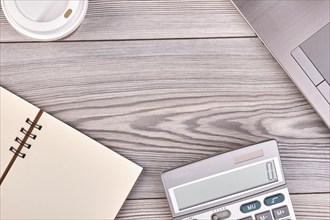 Calculator with blank notepad and copy space. White wood background