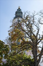 Beautiful baroque church steeple behind a old church in fall, Bavaria