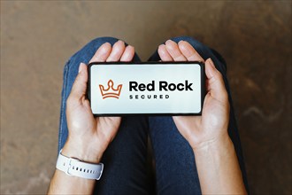 In this photo illustration, the Red Rock Secured logo is displayed on a smartphone screen