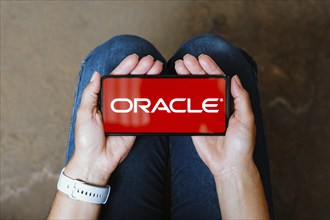 In this photo illustration, the Oracle Corporation logo is displayed on a smartphone screen