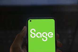 Sage Group logo is displayed on smartphone. Sage Group plc is a British software company