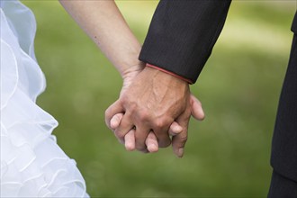 Young married couple holding hands, ceremony wedding day