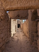 Typical abandoned alleyway surrounded by old clay walls in a little village somewhere in the Draa