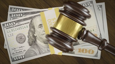 Overhead of gavel resting on a table and stack of thousands of dollars