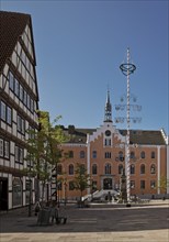 Market square with maypole and town hall in the historic old town with many half-timbered houses,