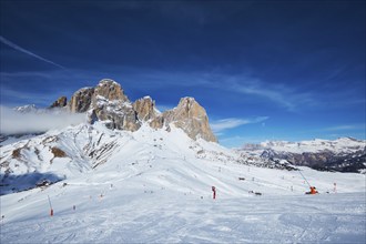 View of a ski resort piste with people skiing in Dolomites in Italy