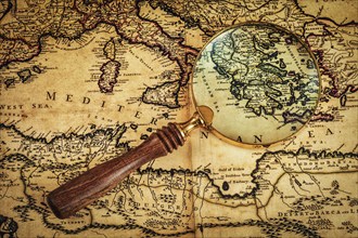 Travel geography navigation concept background, old vintage retro magnifying glass on ancient