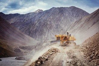 LADAKH, INDIA, SEPTEMBER 10, 2011: Bulldozer cleaning road after landslide in Himalayas. Ladakh,